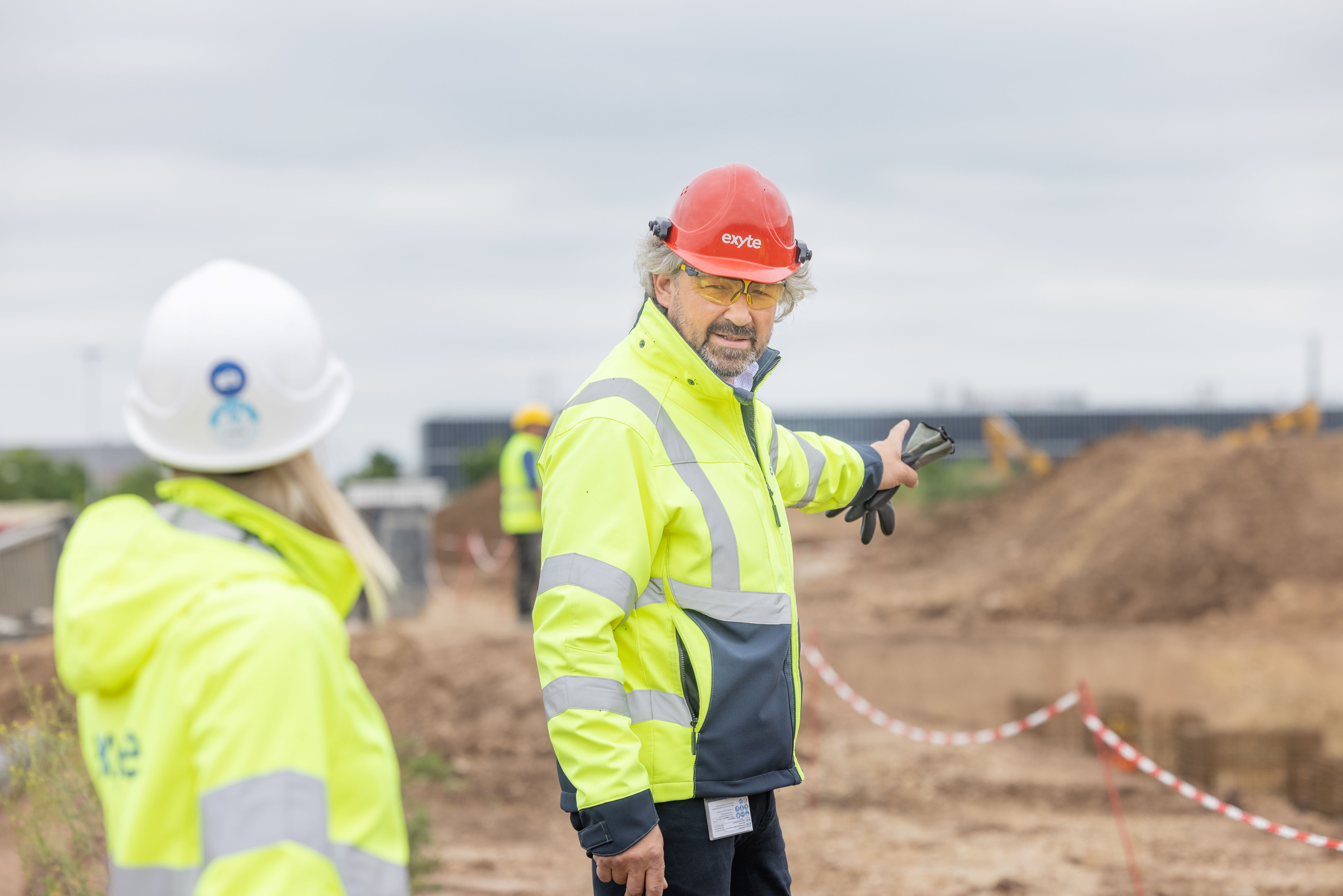 Exyte employees in safety gear on a construction site