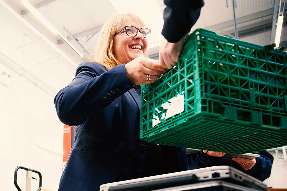 Image of person handing a crate to another person