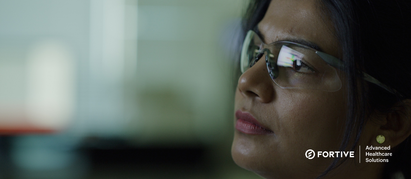 Female ASP employee with safety glasses analyzing data on a screen