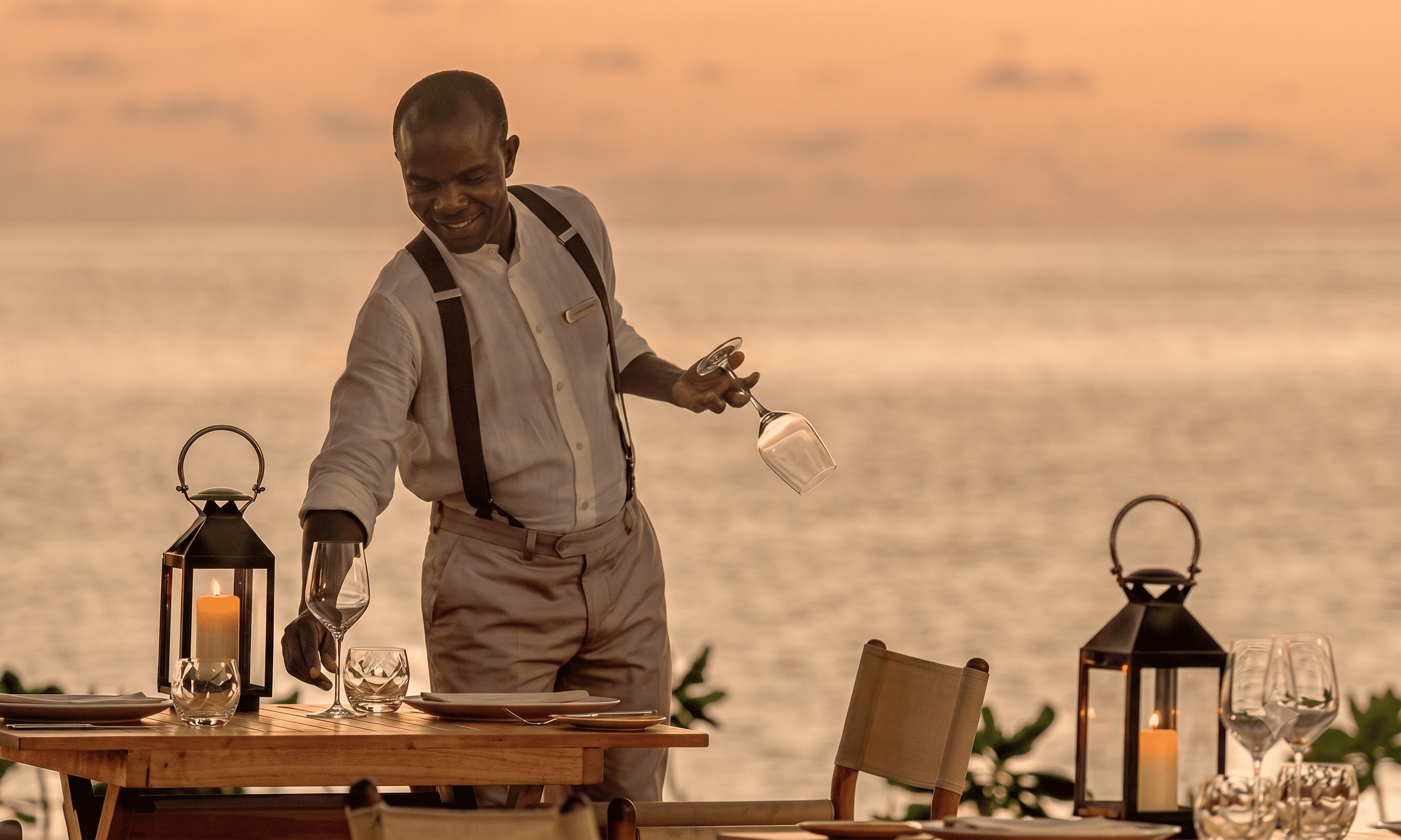 A waiting near the ocean setting a table.
