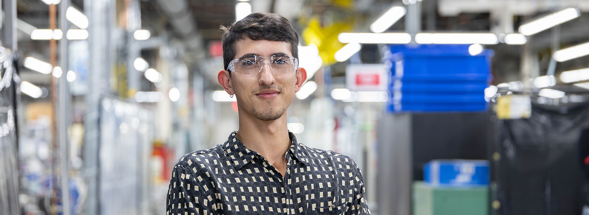 A man standing in a factory setting. 