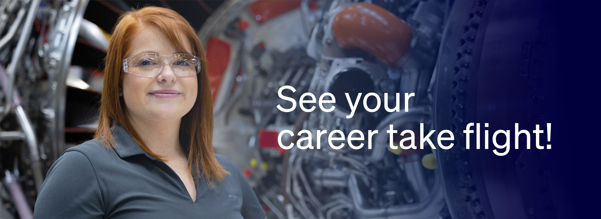 Employee smiling at camera with jet engine behind them.