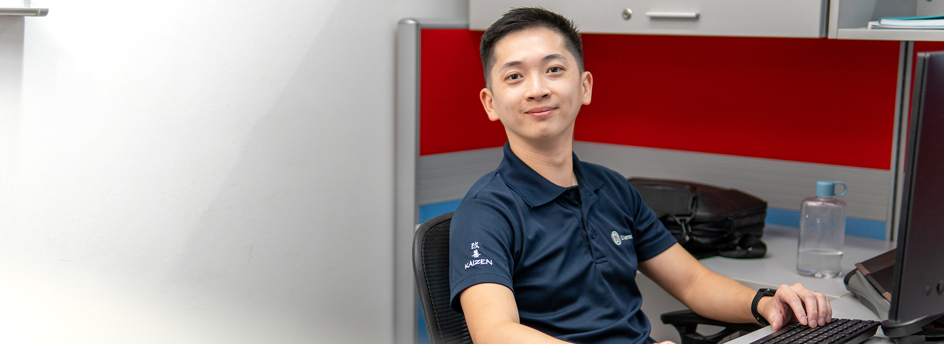 Young person sitting at a desk with a computer.