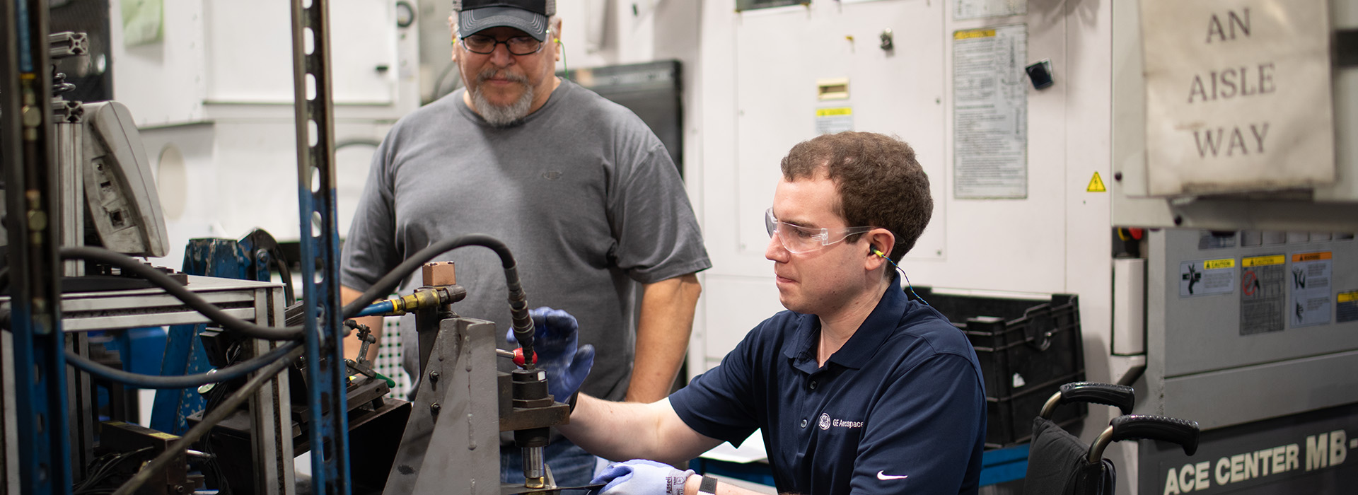 Two men working with manufacturing equipment