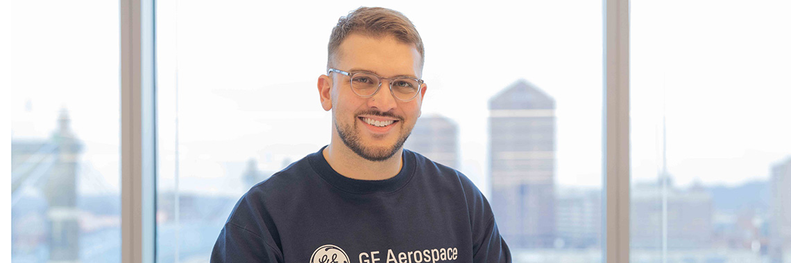 Young man smiling at camera with GE Aerospace shirt on