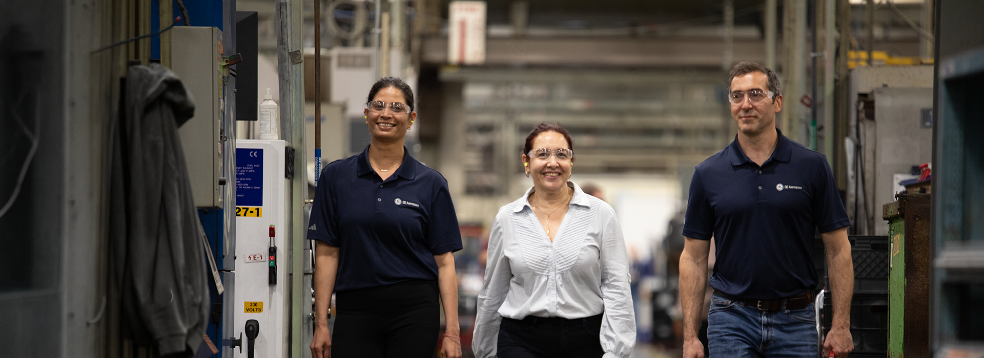3 employees walking through manufacturing facility