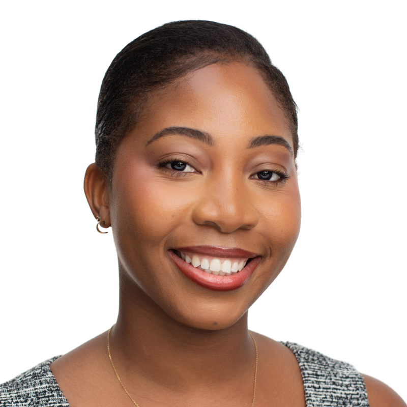 A young woman smiling with dark hair pulled back
