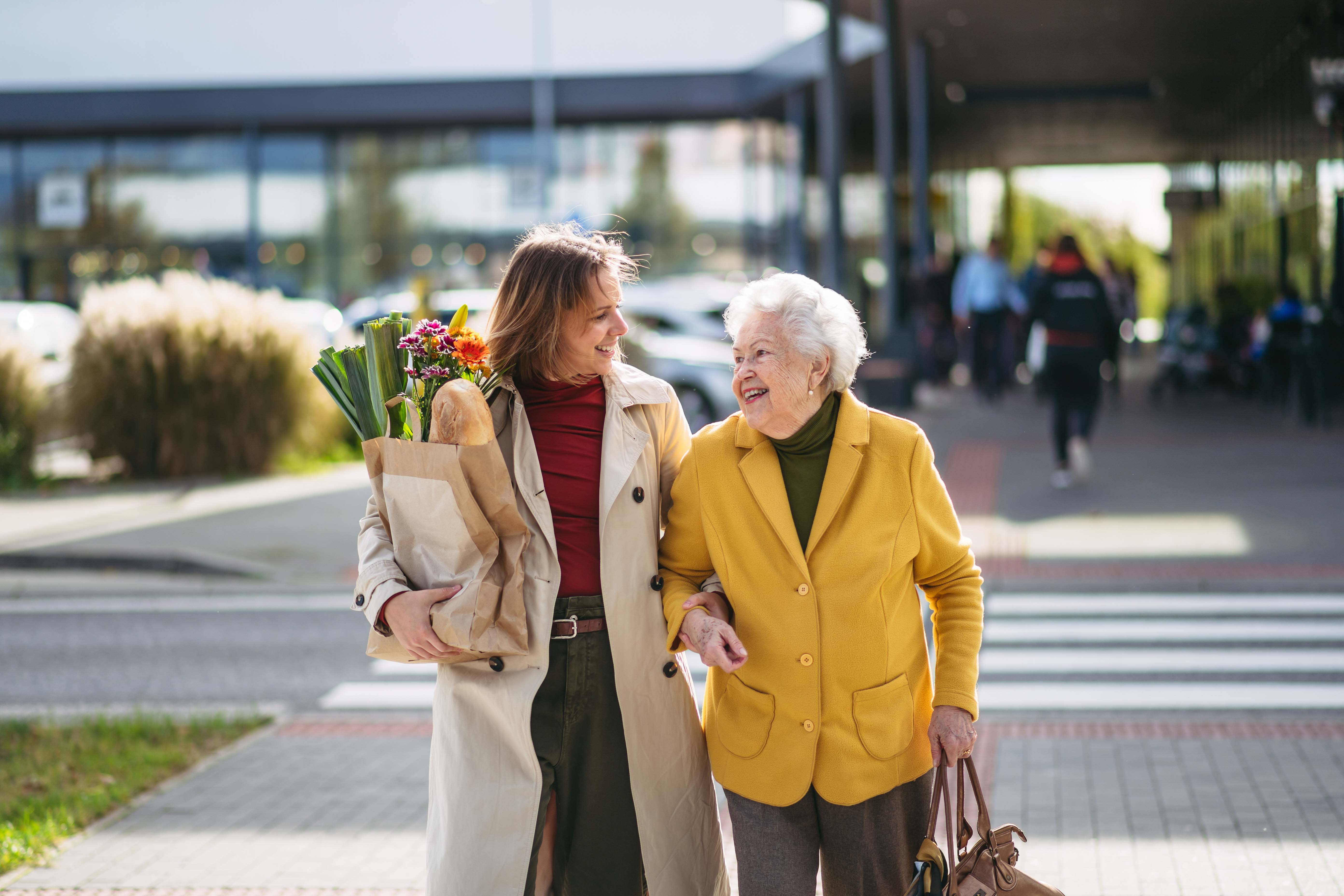 Adult daughter and older adult mom smiling