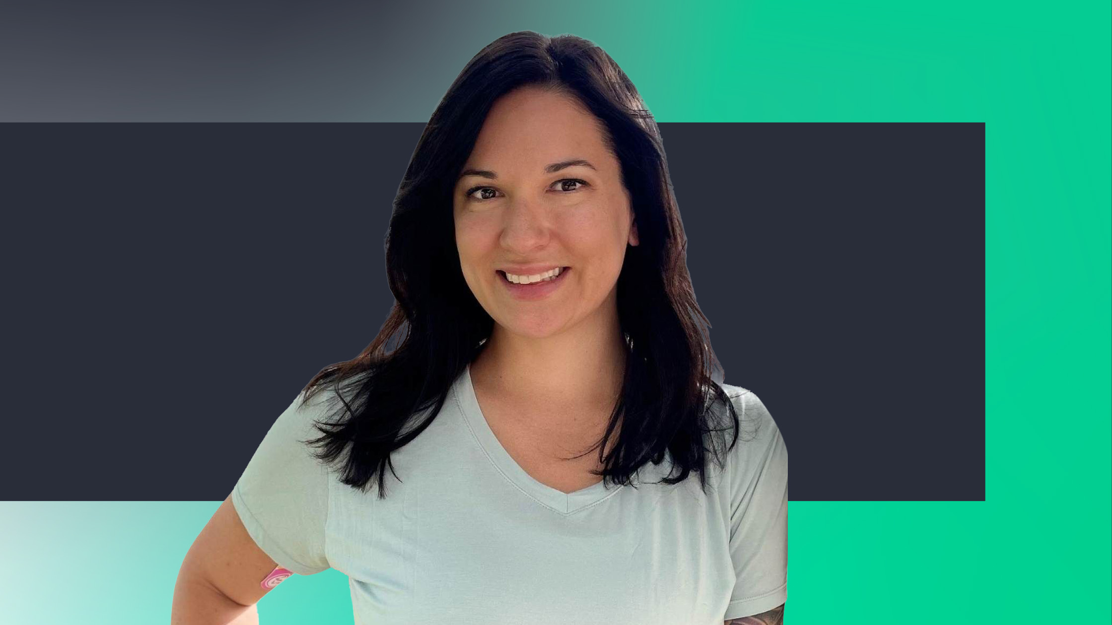 A woman with long dark hair and a light-colored t-shirt smiles at the camera, standing in front of a teal and dark gray geometric background.