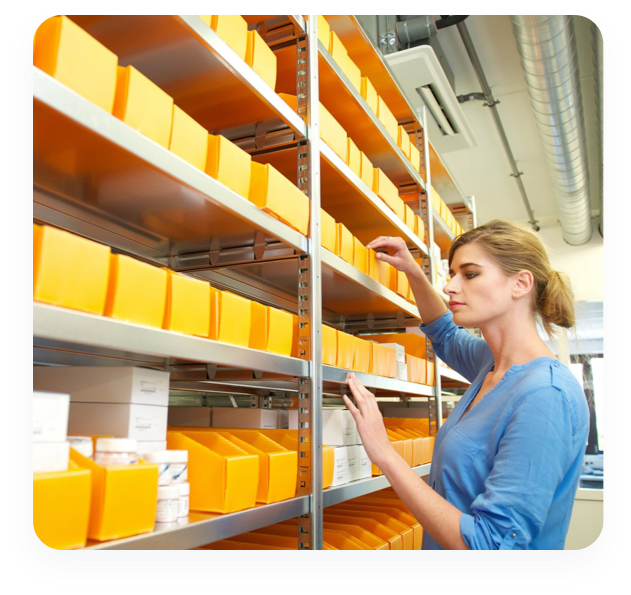 An employee checks the inventory on a shelf at a pharmacy distribution center.