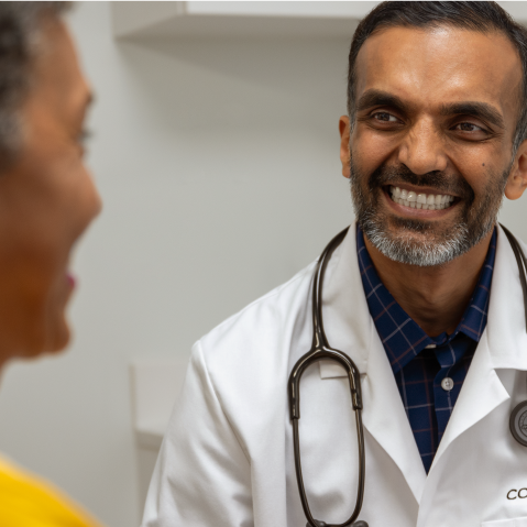 A Conviva physician sitting and talking with a patient about his plan of care.