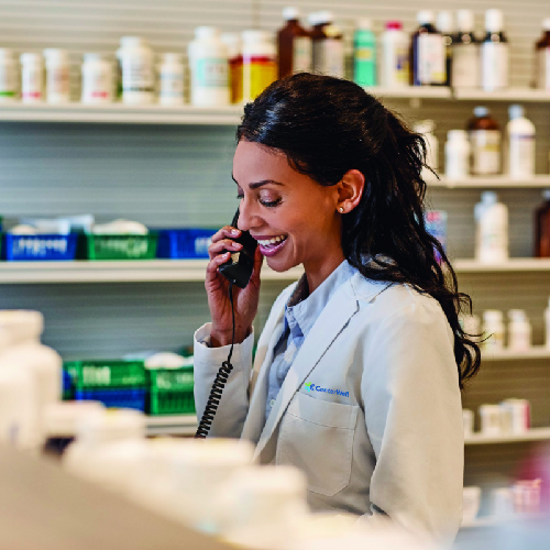 Pharmacist with a friendly smile talking on the phone.