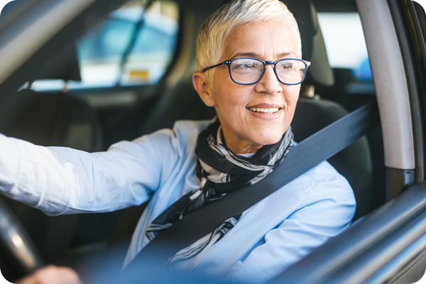 A CenterWell Home Health Nurse clinician sitting in the drivers seat of a company car.