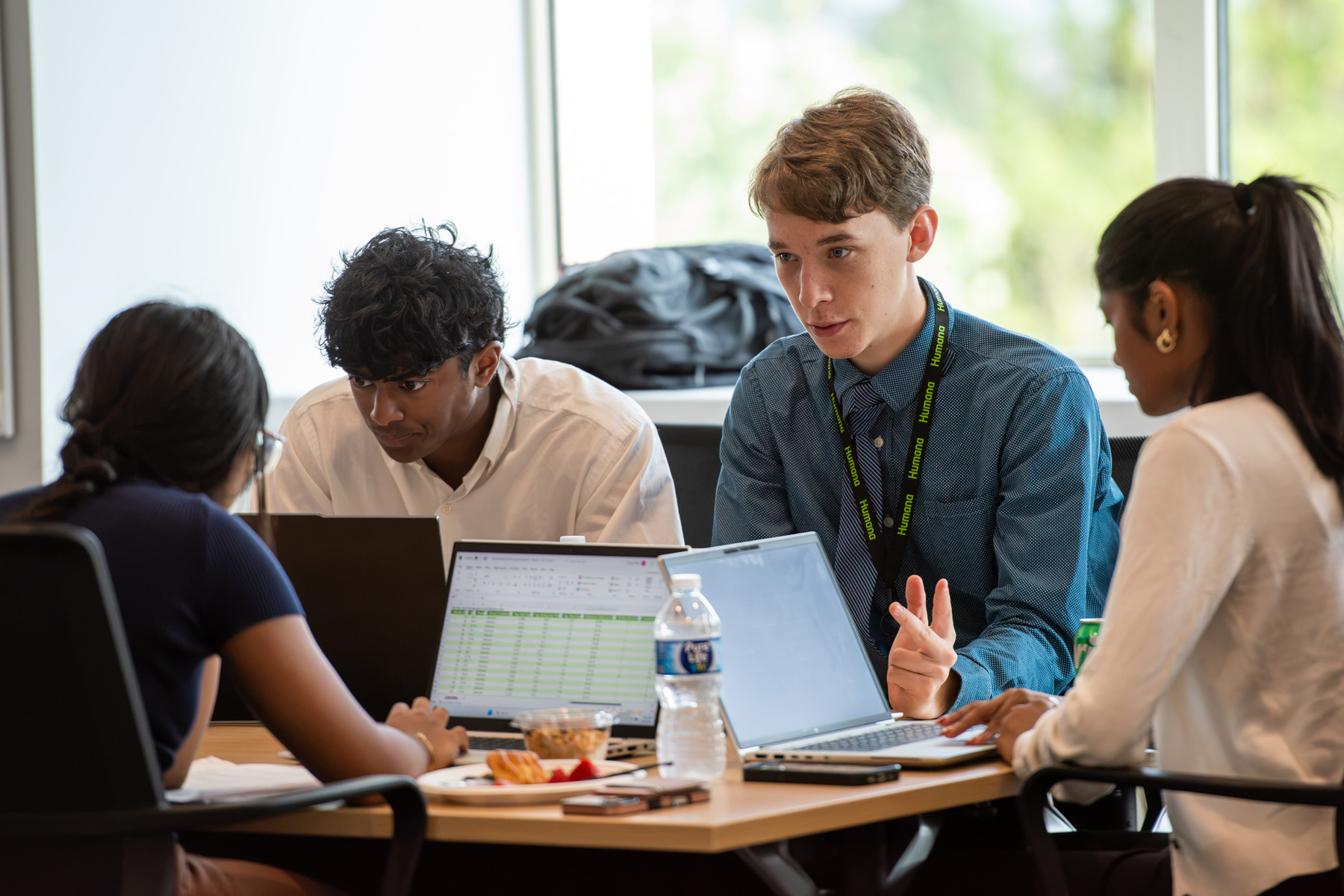 Small group of Humana interns collaborating together on a project sitting together around a table