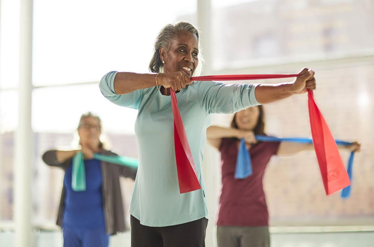 Group of women using stretch bands in a fitness class