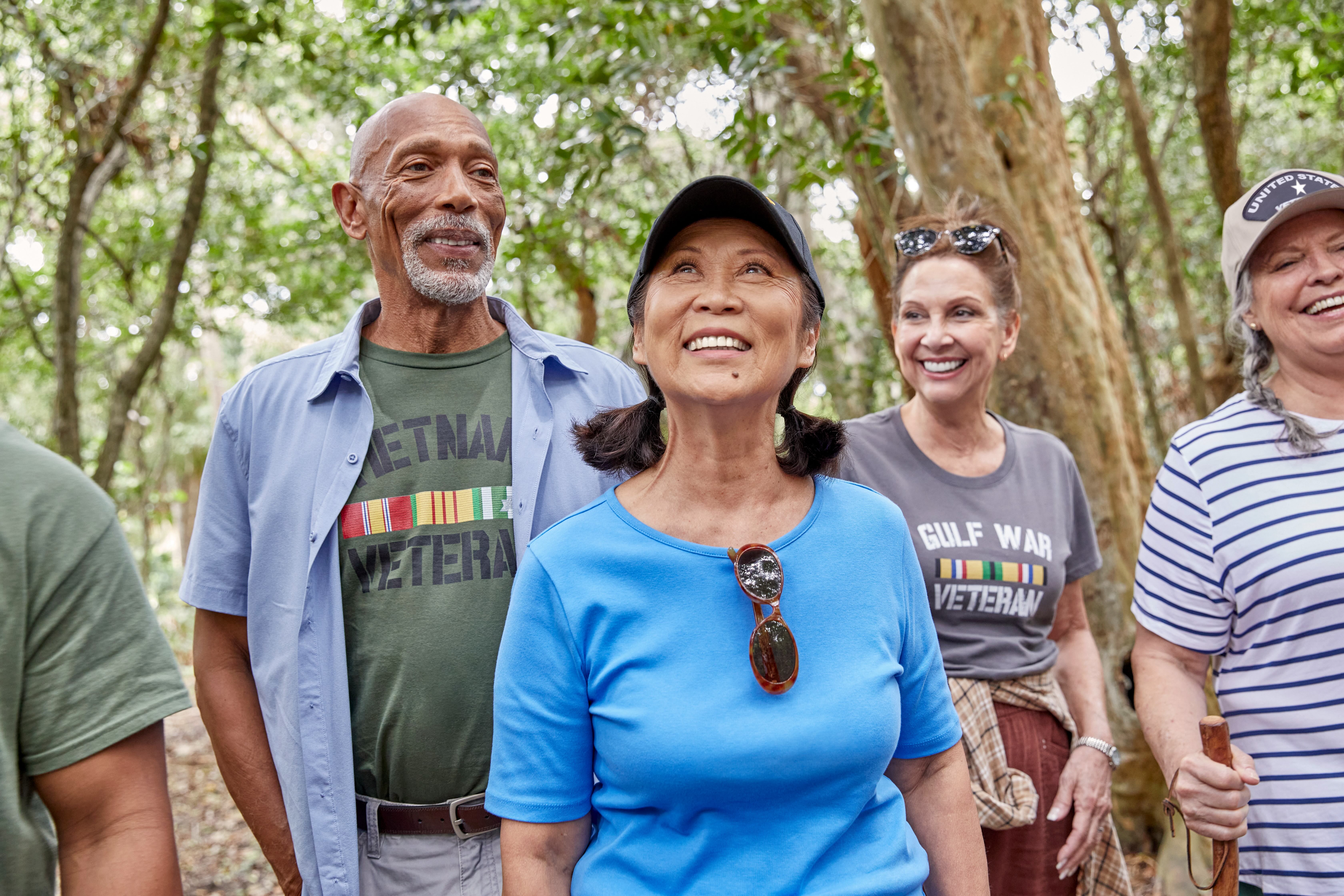 A group of men and women Veterans smiling on a walking trail.