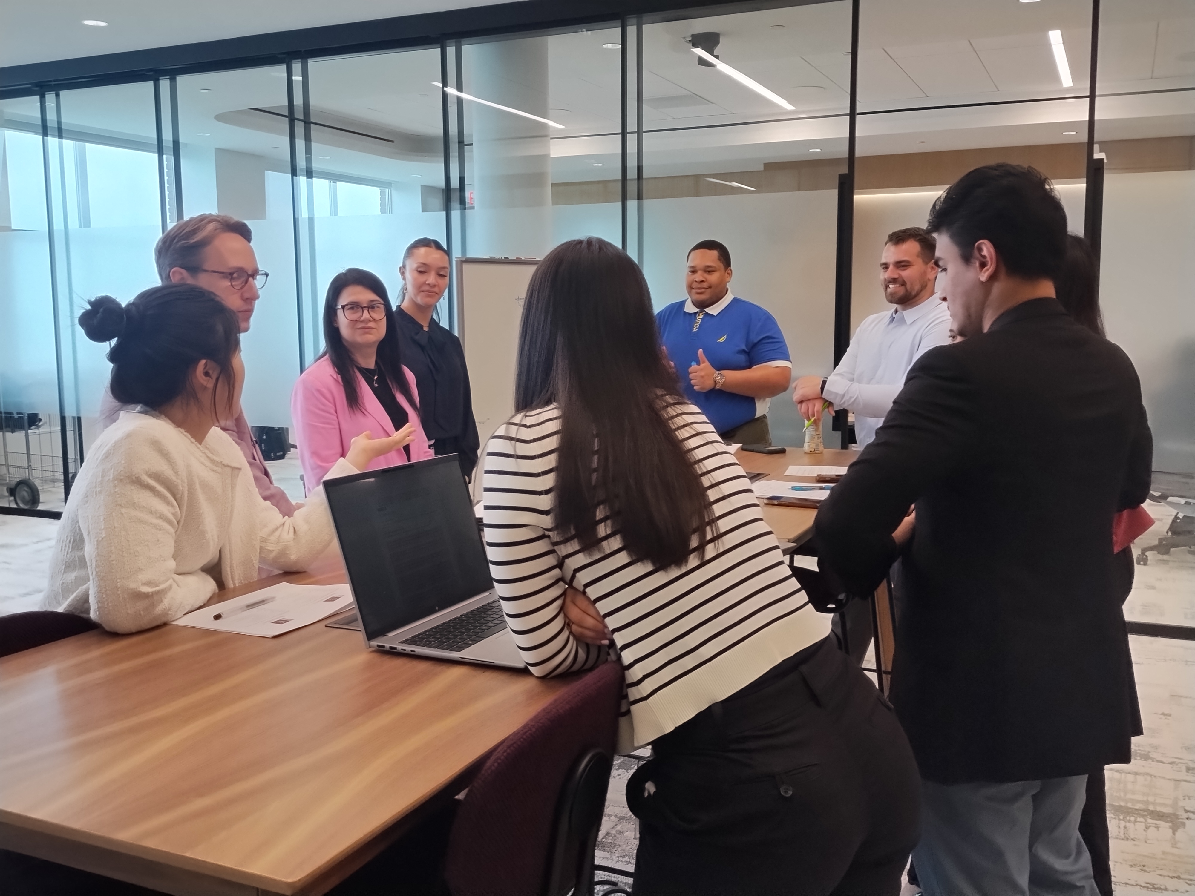 Small group of professionals gathered around table collaborating on project