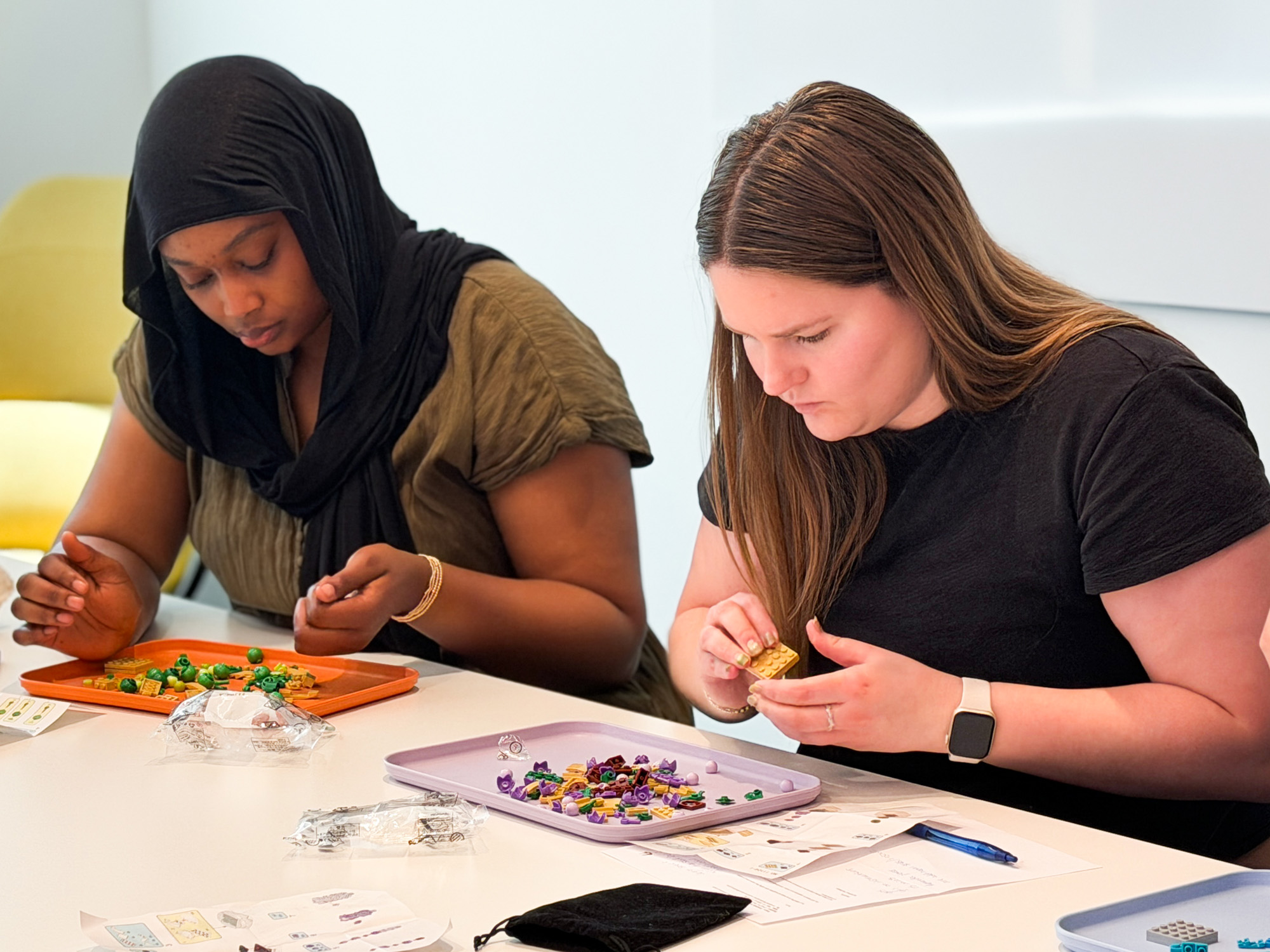 Two female students doing a communication exercise with lego blocks