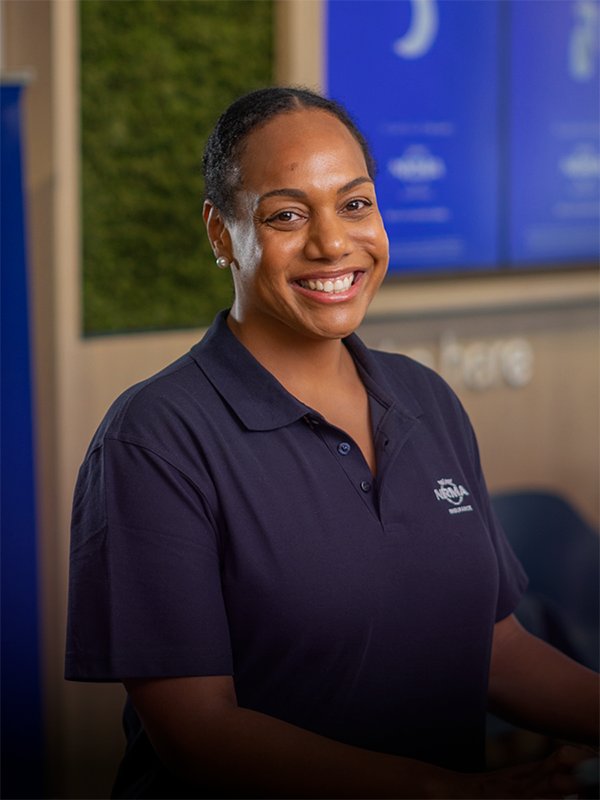 Insurance staff member at service desk, smiling at camera