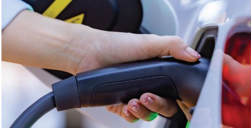 woman plugging electric car