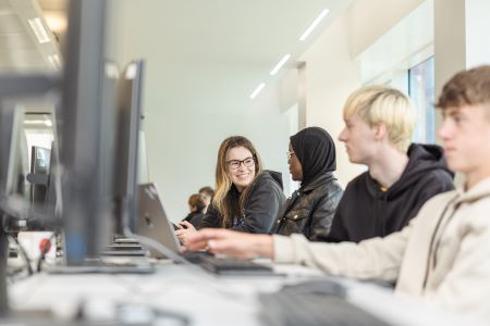 group of students gathered around computers