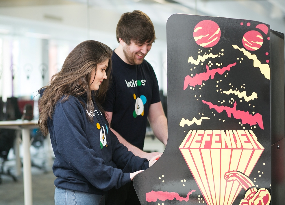 two people play a retro arcade game