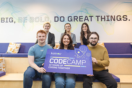 group of people holding a sign for CodeCamp