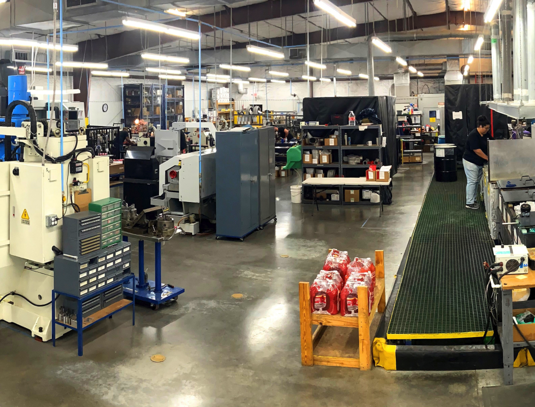 Wide view of Cadorath’s manufacturing floor showing CNC machines, workstations, and technicians inside a large industrial facility in Lafayette, Louisiana.