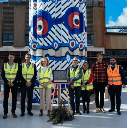 CEO, Managing Director and other Lion team members at Tooheys brewery in front of aboriginal art and leaves for a smoke ceremony