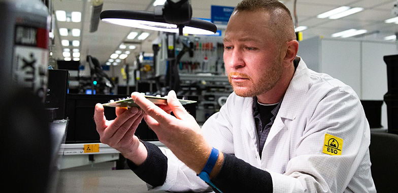 Person in lab coat working on a med device component