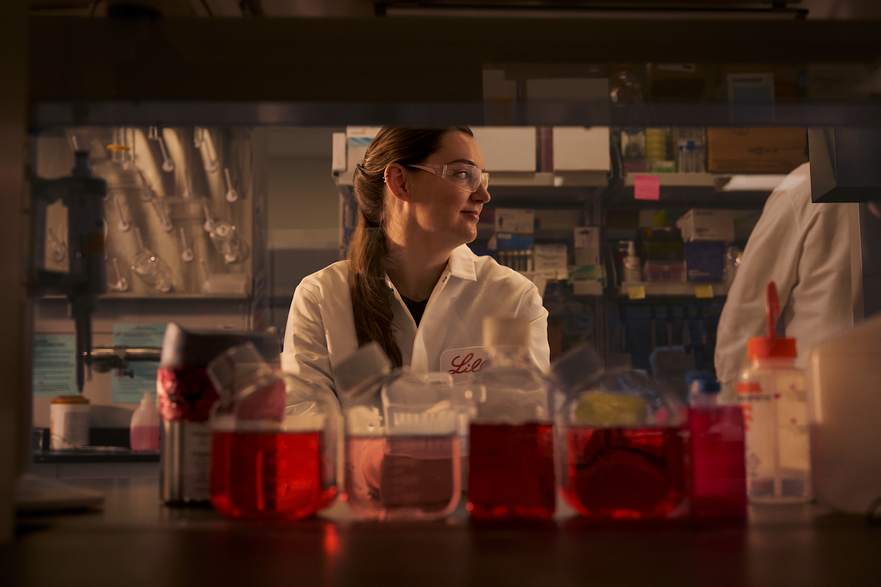 Man with lab glasses and jacket working in a research facility
