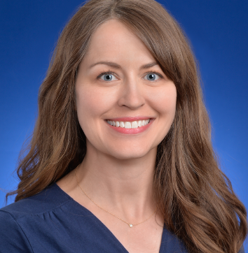 Headshot image with blue background of Karen Chilcott Holdridge, a Caucasian woman, smiling