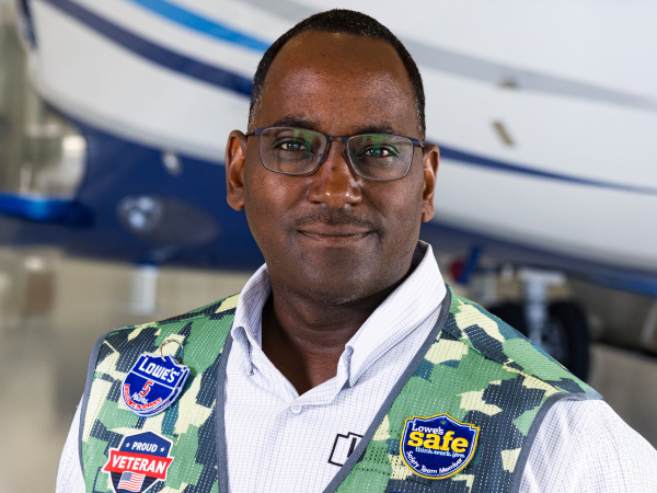 Aviation associate standing in front of a Lowe's airplane