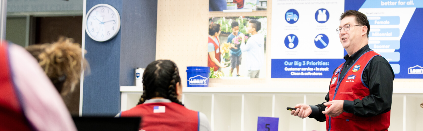 Lowe’s associates in red vests attend a training session.