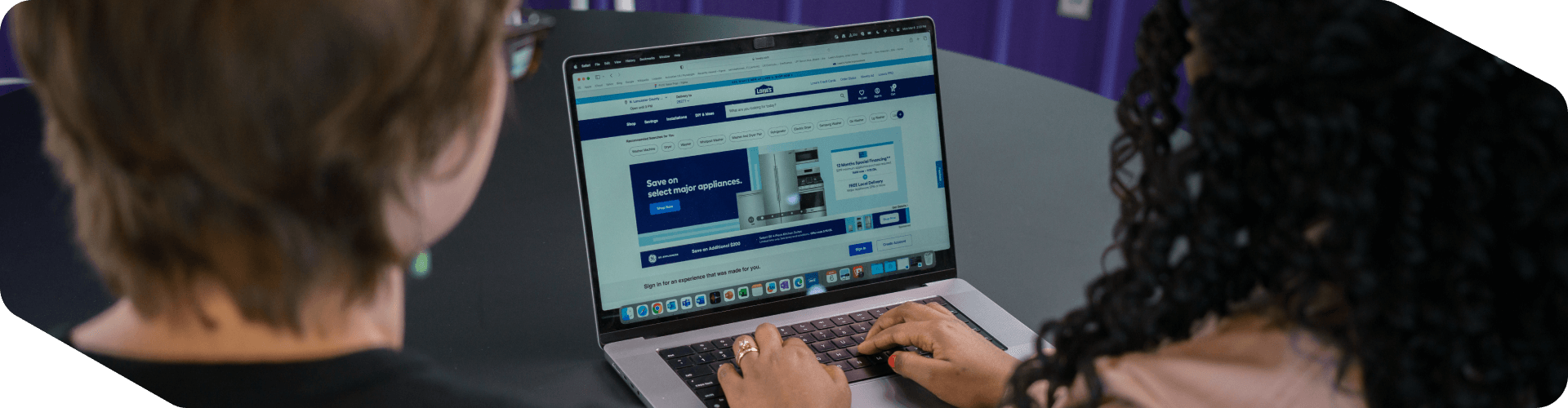 Two associates working on a laptop together