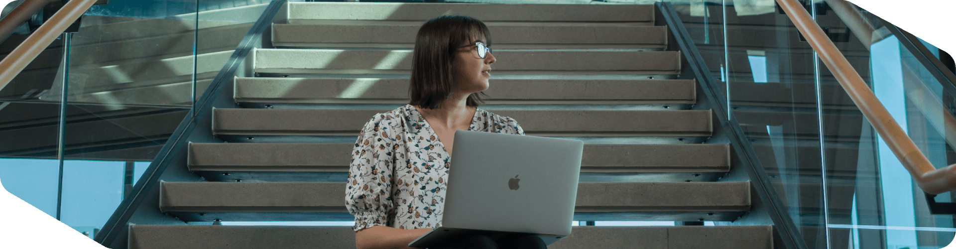 Lowe's associate working on her laptop on the steps of the Tech Hub