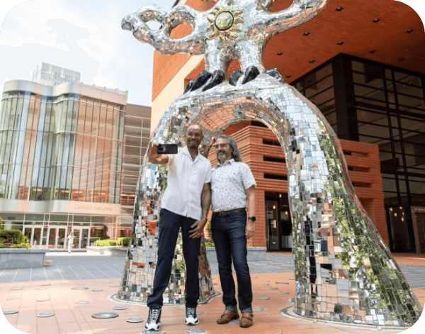 People taking a picture in front of a monument in Charlotte
