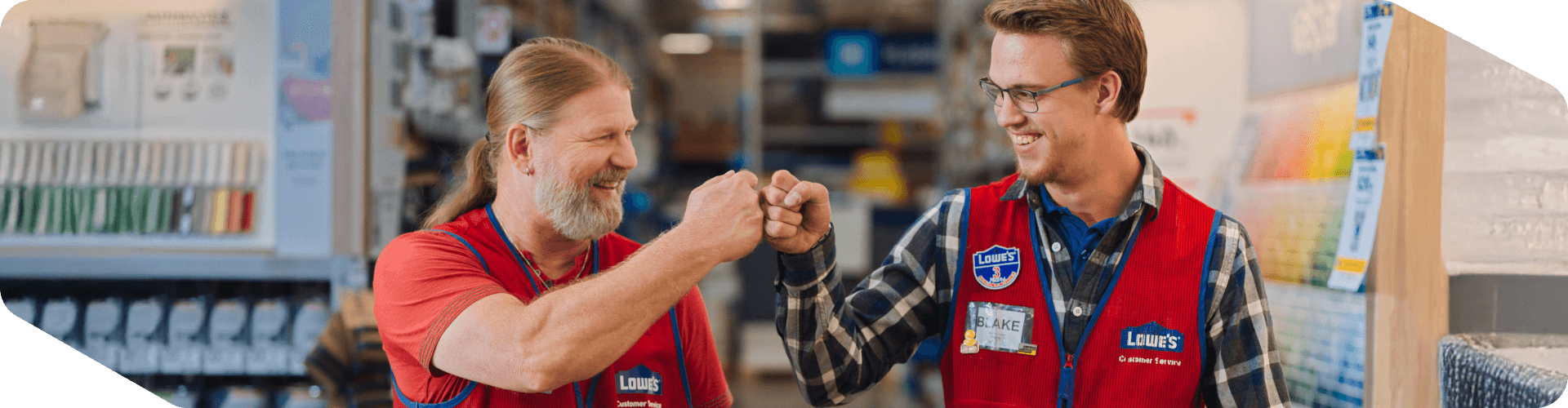 Two Lowe's associates fist bumping in the paint department