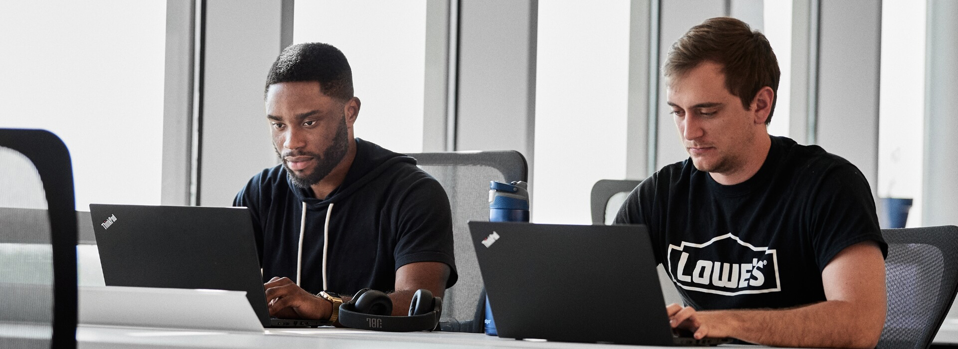 Two male colleagues working on laptops