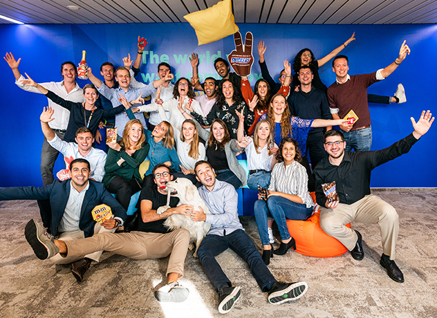 A group photo of 20+ Mars Associates with a blue background