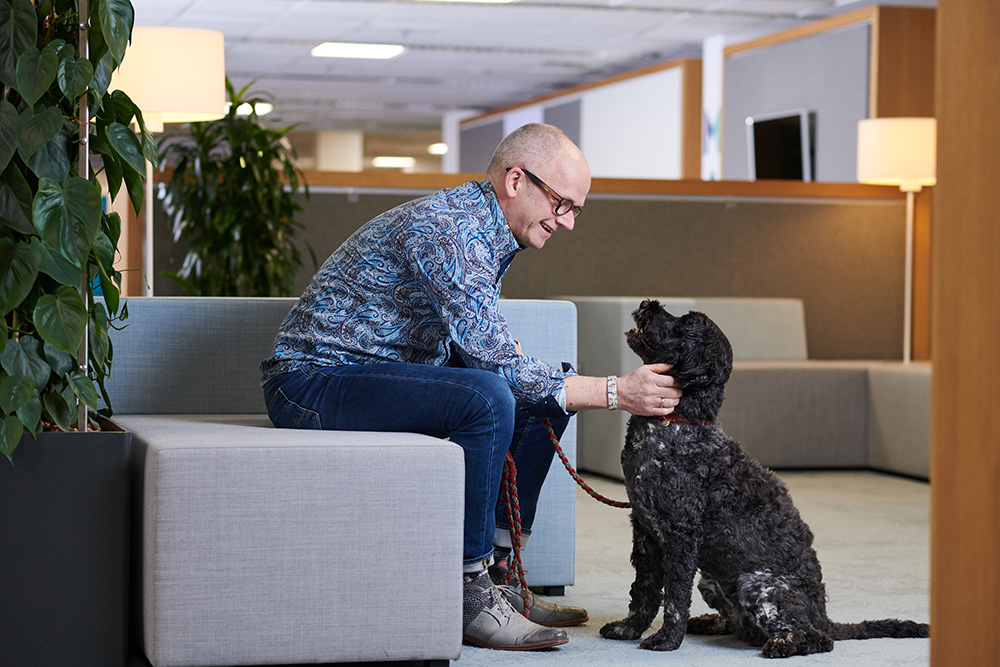 An image of a Mars Associate leaning down to pet their dog,