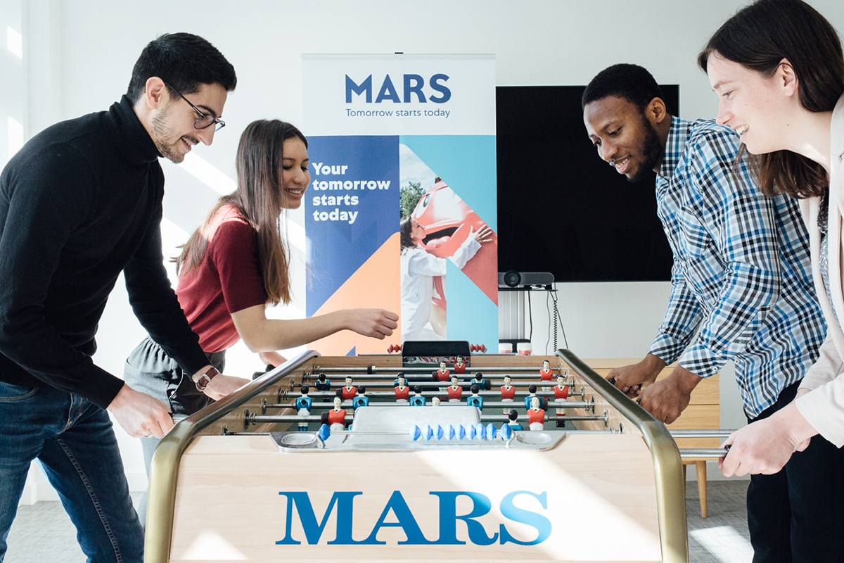 A image of 4 Mars Associates playing on a foosball table