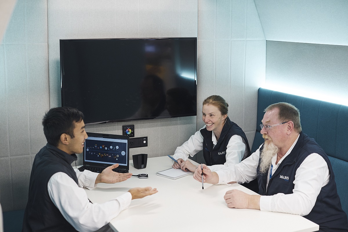 A image of a 3 Mars Associates around a table engaged in conversation