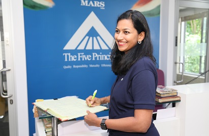 A image of a Mars Associate smiling and putting pen to paper