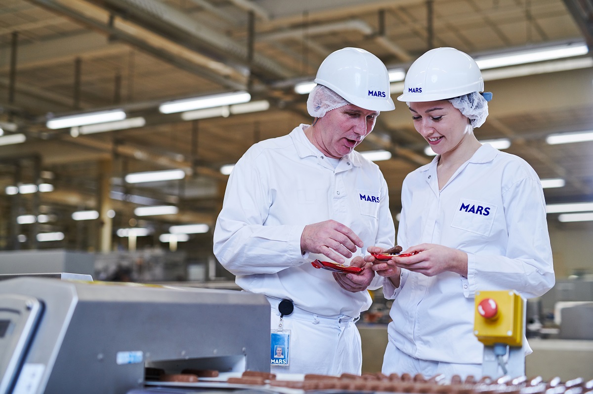 A image of 2 Mars Associates in white mars uniform and PPE quality controlling products.