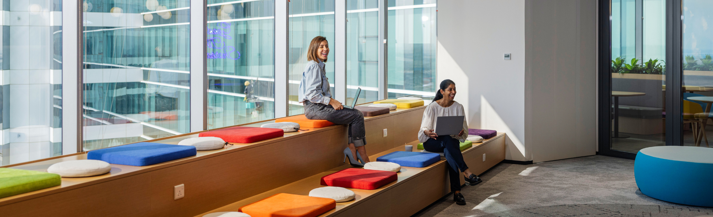 Two Associates in the office sitting and smiling 