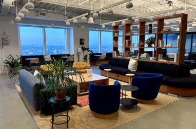 Seating area in Mastercard Bogota office featuring beige and cream couches and chairs with floor-to-ceiling windows.