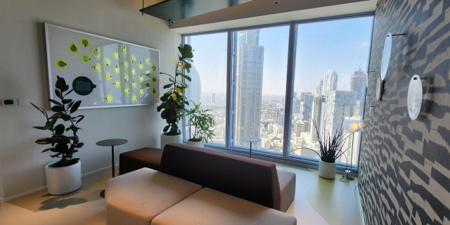 A cozy area in Mastercard's Tel Aviv office featuring comfortable couches, with large windows offering stunning views of the city.