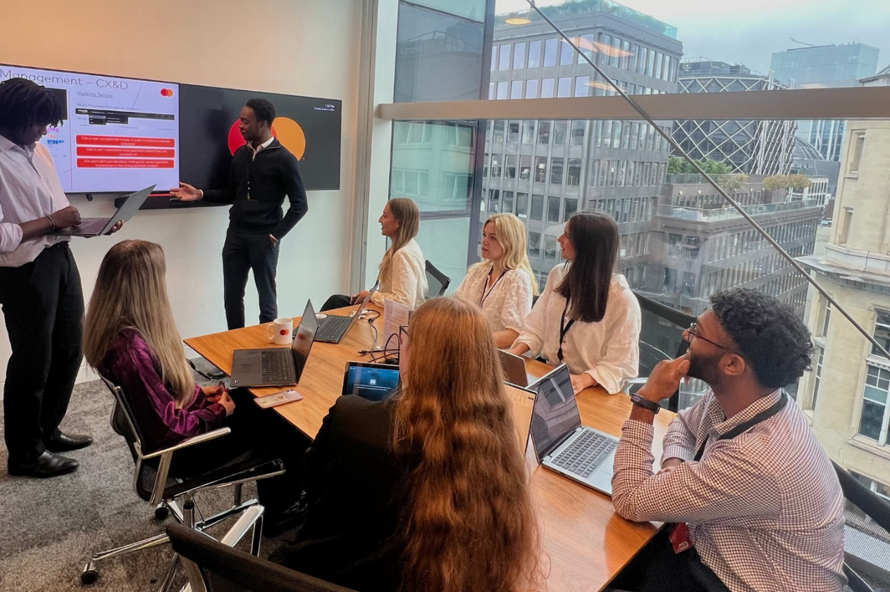 Group of mastercard interns presenting in a conference room infront of their peers