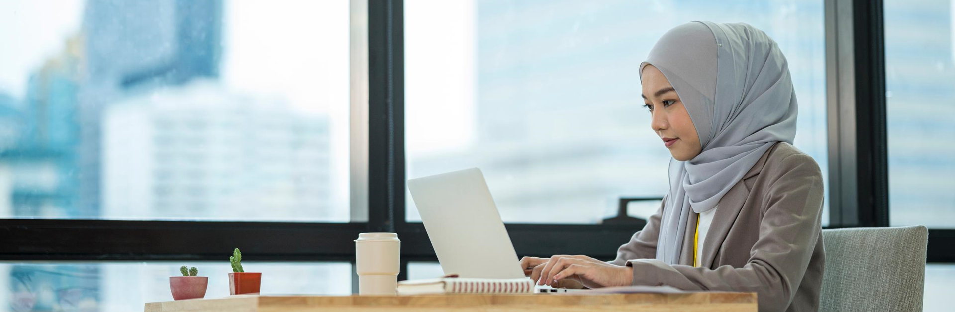 Mujer sentada escribiendo en una laptop